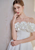 Graduate in a white LARMES Peony A-line dress with floral ruffles at the bust