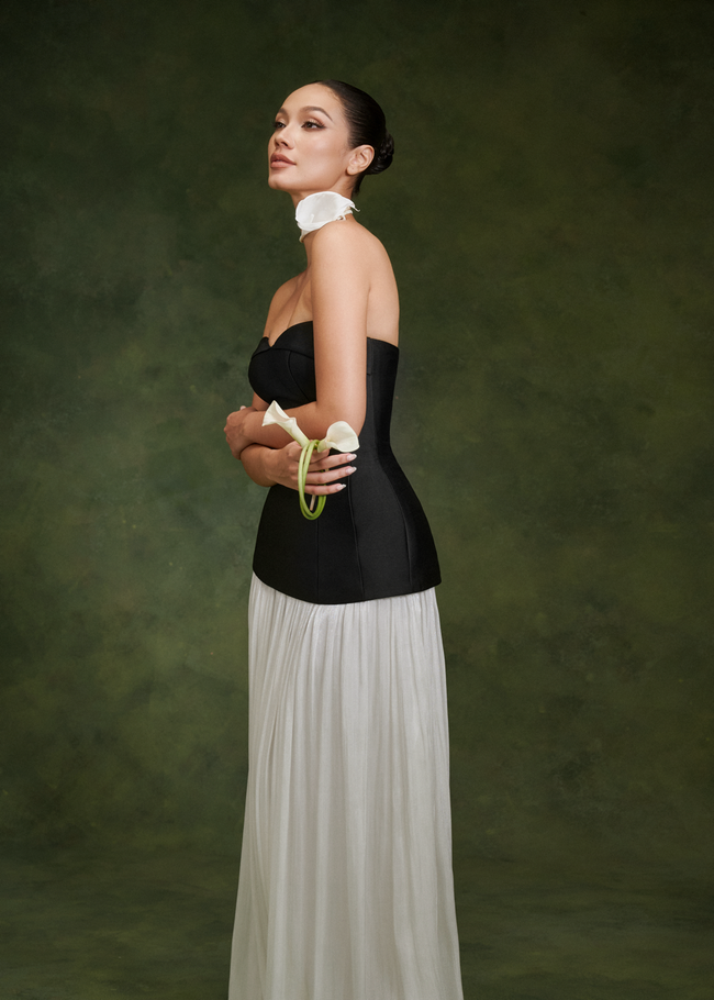 Fanny top in black and Wisteria skirt in ivory – side view, holding calla lilies